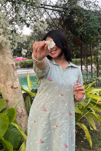 Woman holding a flower in front of her face with a garden background